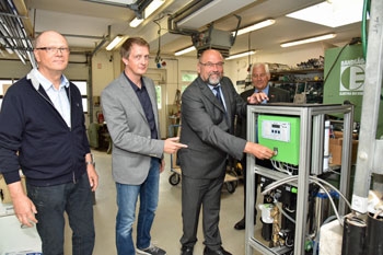 Wirtschaftsminister Harry Glawe nimmt ein Gerät in einer Werkshalle in Betrieb Wirtschaftsminister Harry Glawe nimmt ein Gerät in einer Werkshalle in Betrieb
