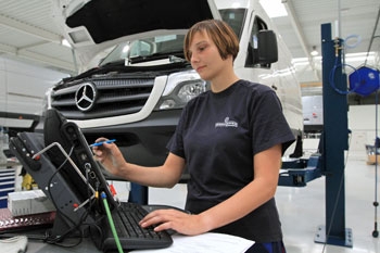 Junge Frau in einer Werks­hal­le der Au­to­mobil­her­stel­lung; Foto: Nor­bert Fellechner